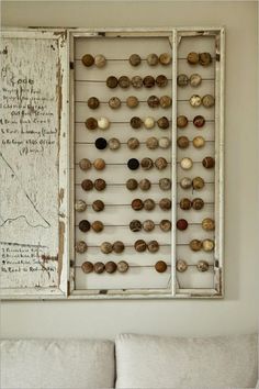 a white couch sitting next to a wall mounted with shells on it's side