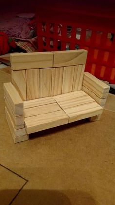 a bench made out of wood sitting on top of a floor next to a basket