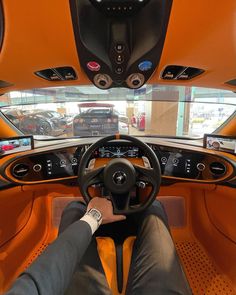 the interior of an orange sports car with dashboard lights and steering wheel, as seen from above