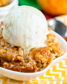 a close up of a bowl of food with ice cream on top and fruit in the background