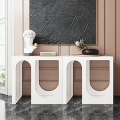 a white console table with two vases and a painting on the wall behind it