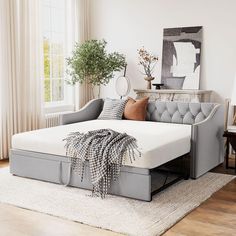 a living room with a couch, chair and rug on the floor in front of a window