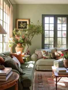 a living room filled with lots of furniture and plants on top of windowsills