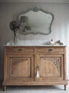 a large wooden cabinet with a mirror above it