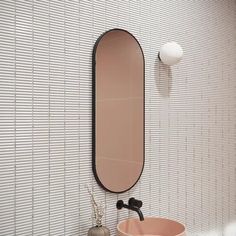 a bathroom with a sink, mirror and vase on the wall in front of it