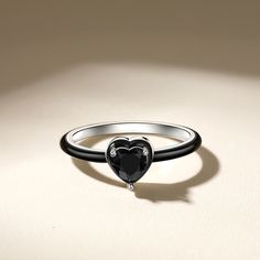 Make an impact on your look with the black heart ring. This boldly designed ring features a black heart shaped stone in the centre, black enamel around the halo and band, and sterling silver fluting at the base of the ring. This ring is a bold reflection of love for yourself and others, and the power of colour.Carat Weight: 0.44 ctStone Size: 5*5 mmStone Type: Jeulia® StoneNumber of Stones: 1 Stone Color: Fancy BlackStone Shape: HeartWeight: 1.9 gWidth: 1.3 mmHeight: 5 mmThickness: 1.3 mmMateria Silver Enamel Ring With Black Detail For Anniversary, Black Enamel Jewelry As Gift, Black Enamel Jewelry For Gift, Black Enamel Jewelry For Gifts, Anniversary Silver Ring With Black Enamel, Elegant Black Enamel Jewelry, Silver Black Enamel Ring For Anniversary, Black Enamel Rings For Anniversary, Black Sterling Silver Rings For Anniversary