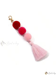 three pom - poms hanging from a keychain on a white background