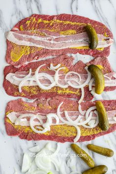 an image of raw meat with onions and pickles on the side for grilling