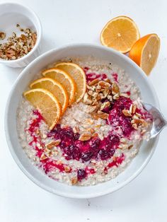 a bowl of oatmeal with orange slices and granola on the side