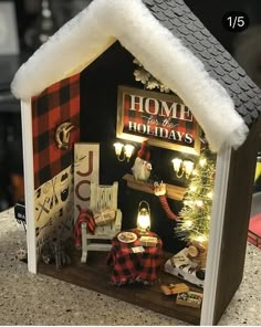 a doll house with christmas decorations and lights on the front door is decorated in red, white and black