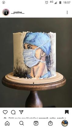 a cake with a painting of a woman wearing a surgical mask on top of it