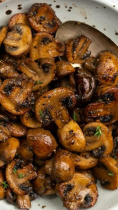 mushrooms are in a white bowl with a wooden spoon