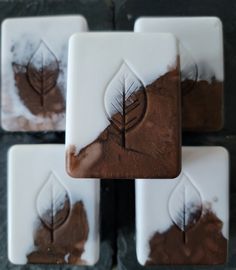 four square coasters with leaf designs on them