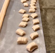 doughnuts are lined up on a baking sheet and ready to go into the oven