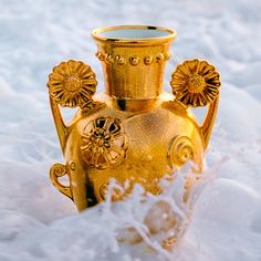 an ornate gold vase sitting in the snow