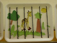 three trays filled with different types of paper cut out of trees and giraffes