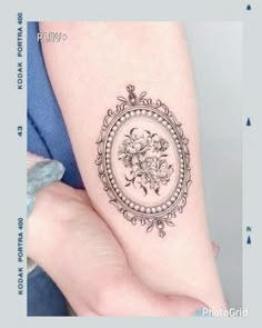 a woman's arm with a flower tattoo on it