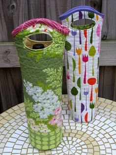 two vases sitting on top of a table next to each other