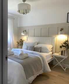 a white bed sitting in a bedroom next to a window