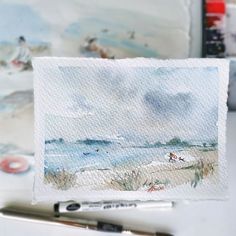 a watercolor painting of a beach scene