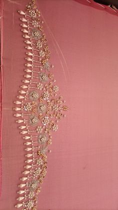 an embroidered pink fabric with gold and white beads on the side, along with other decorative items