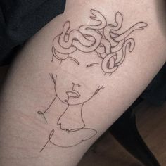 a woman's leg with a tattoo on it that has a snake in her hair