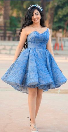 a woman in a blue dress is posing for the camera