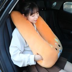 a woman sitting in the back seat of a car with an inflatable pillow