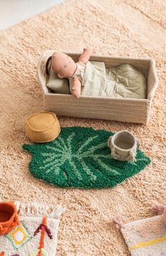 a baby laying in a box on the floor next to other toys and rugs