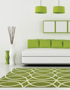 a green and white living room with modern furniture on the floor, rugs and lamps