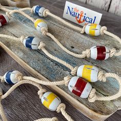 an old wooden boat with rope and colorful beads on the front is sitting on a table