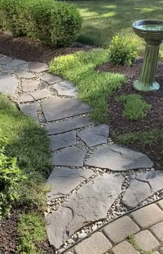 a stone path leading to a bird bath