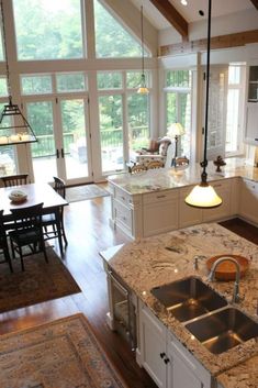 a large kitchen with an island in the middle and lots of windows on both sides