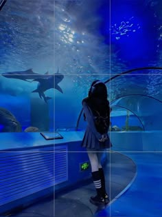 a woman is standing in front of an aquarium with dolphins and other marine creatures on it