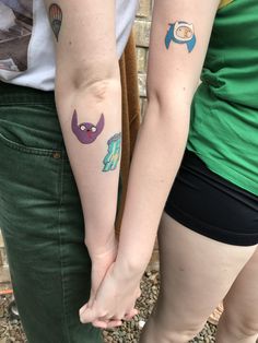 two people with matching tattoos on their arms