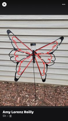 a large metal butterfly with red and black wings