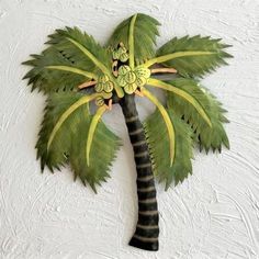 a green palm tree on a white wall