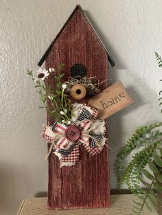 a wooden birdhouse with a sign that says bong on it and some flowers