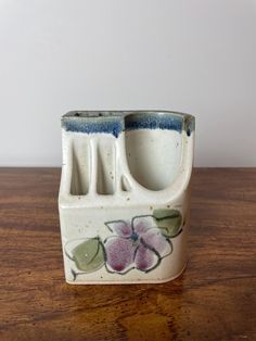 a ceramic container with flowers painted on it