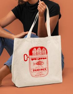 a woman sitting on the floor with a bag in front of her that says sardines