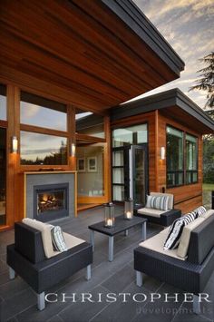 two couches sitting on top of a patio next to a fire place