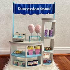 a table with cupcakes, candy and candies on it in front of a sign that says concession stand