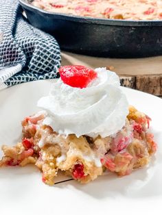 a piece of cake on a plate with whipped cream and strawberry pie in the background