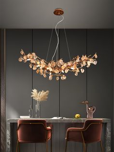 an elegant chandelier hangs over a dining room table with two chairs and a vase