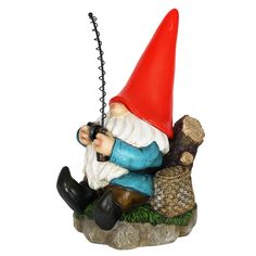 a gnome sitting on a rock with a bird in his hand and holding a camera