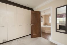 an open door leading to a bathroom with a tub in the background