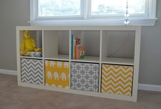 a white shelf with four cubbys and a yellow stuffed animal on the top