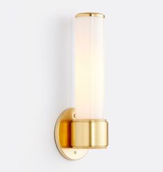 a wall light with a white glass shade on the side and gold trimmings