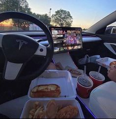 a person is sitting in the driver's seat of a car while watching tv