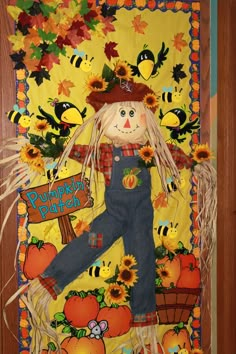 a scarecrow is hanging on the door with pumpkins and bees around it,